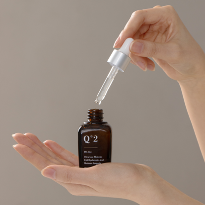 Person using QUA-T Dia ultra-low molecular weight full hyaluronic acid moisture ampoule 30ml with dropper