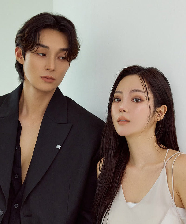 Fashionable duo in stylish attire posing together against a neutral background