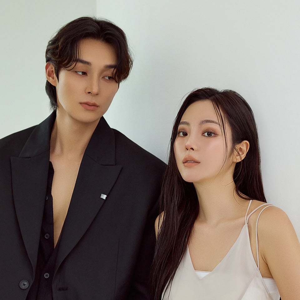 Fashionable duo in stylish attire posing together against a neutral background