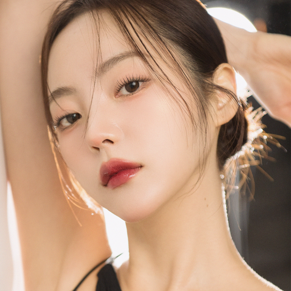 Model showcasing QUA-T The Glass Tattoo Tint with flawless makeup and smooth skin.