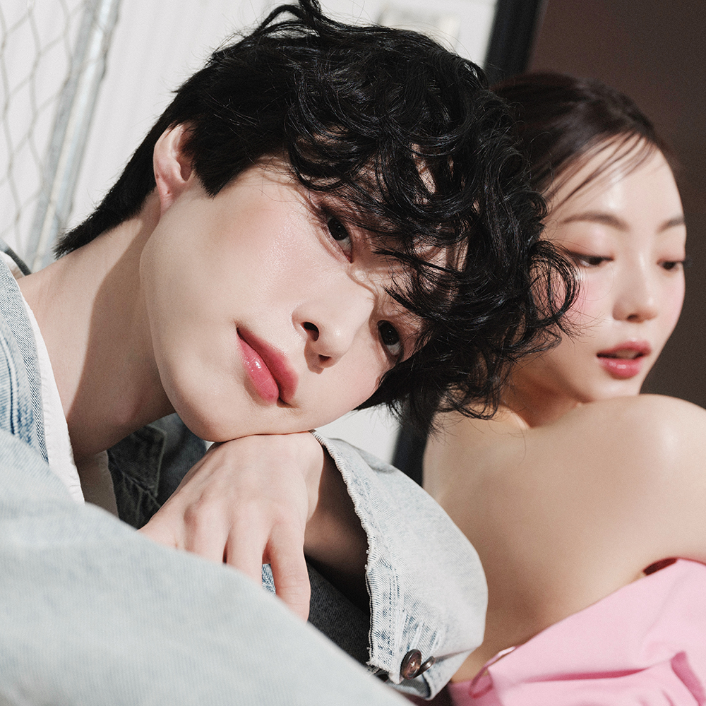 Two models showcasing radiant skin and style, ideal promotion for QUA-T The Glass Tattoo Tint beauty product.