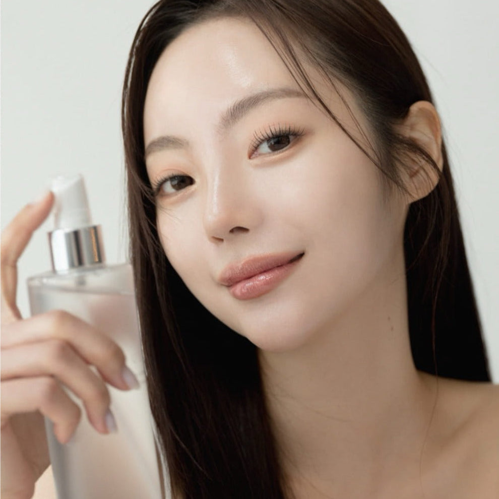 Woman using QUA-T Toner 200ml for skincare routine