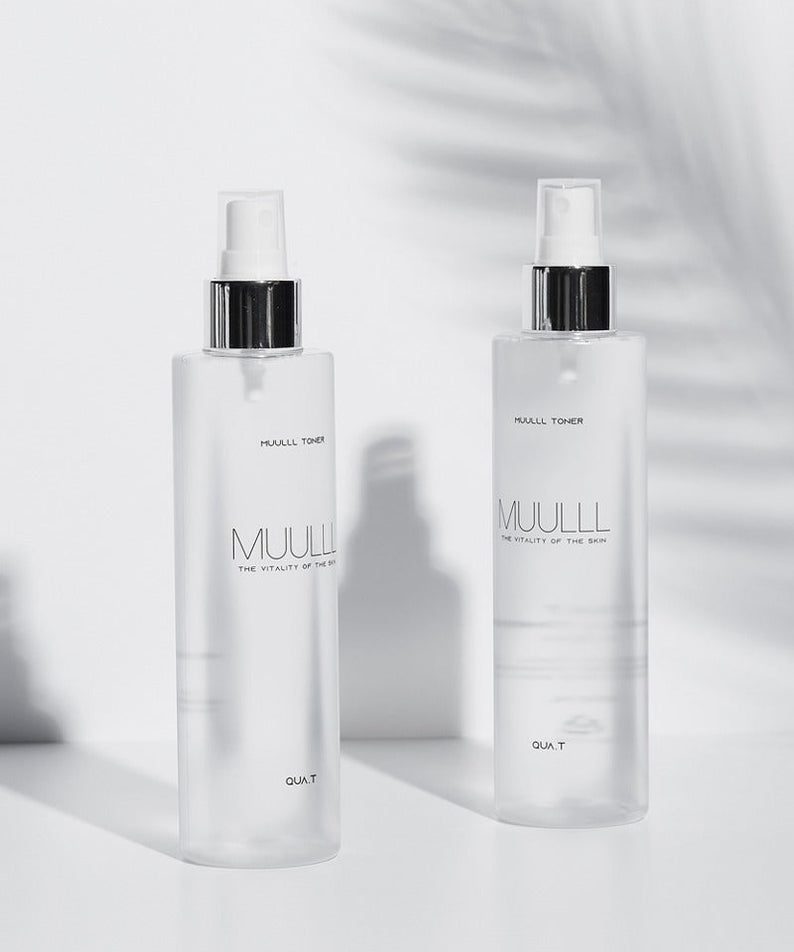 Two bottles of QUA-T Toner 200ml on a white surface with a shadow.