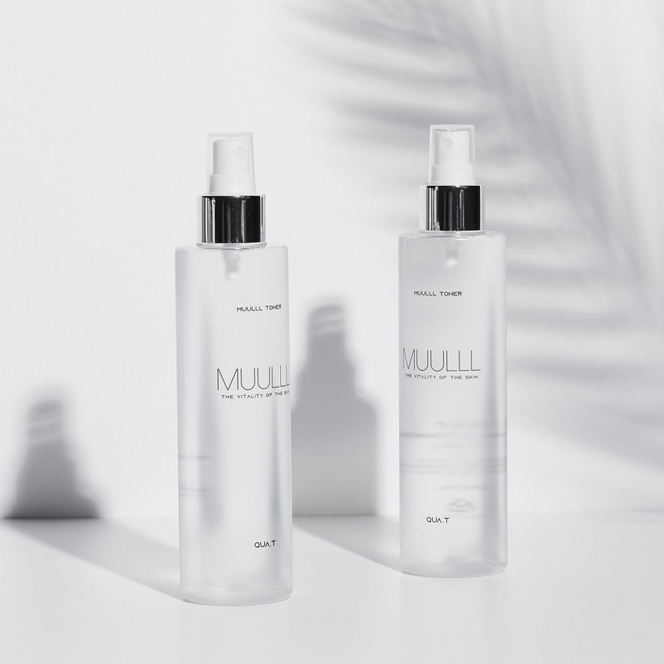 Two bottles of QUA-T Toner 200ml on a white surface with a shadow.