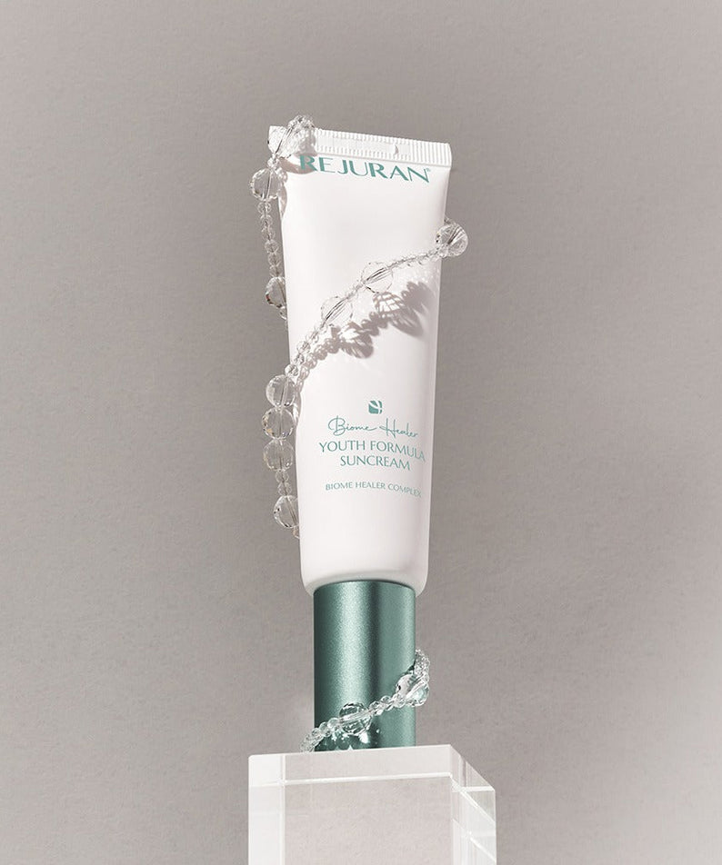 REJURAN Biome Healer Touth Formula Sunscreen 50ml displayed with decorative elements.