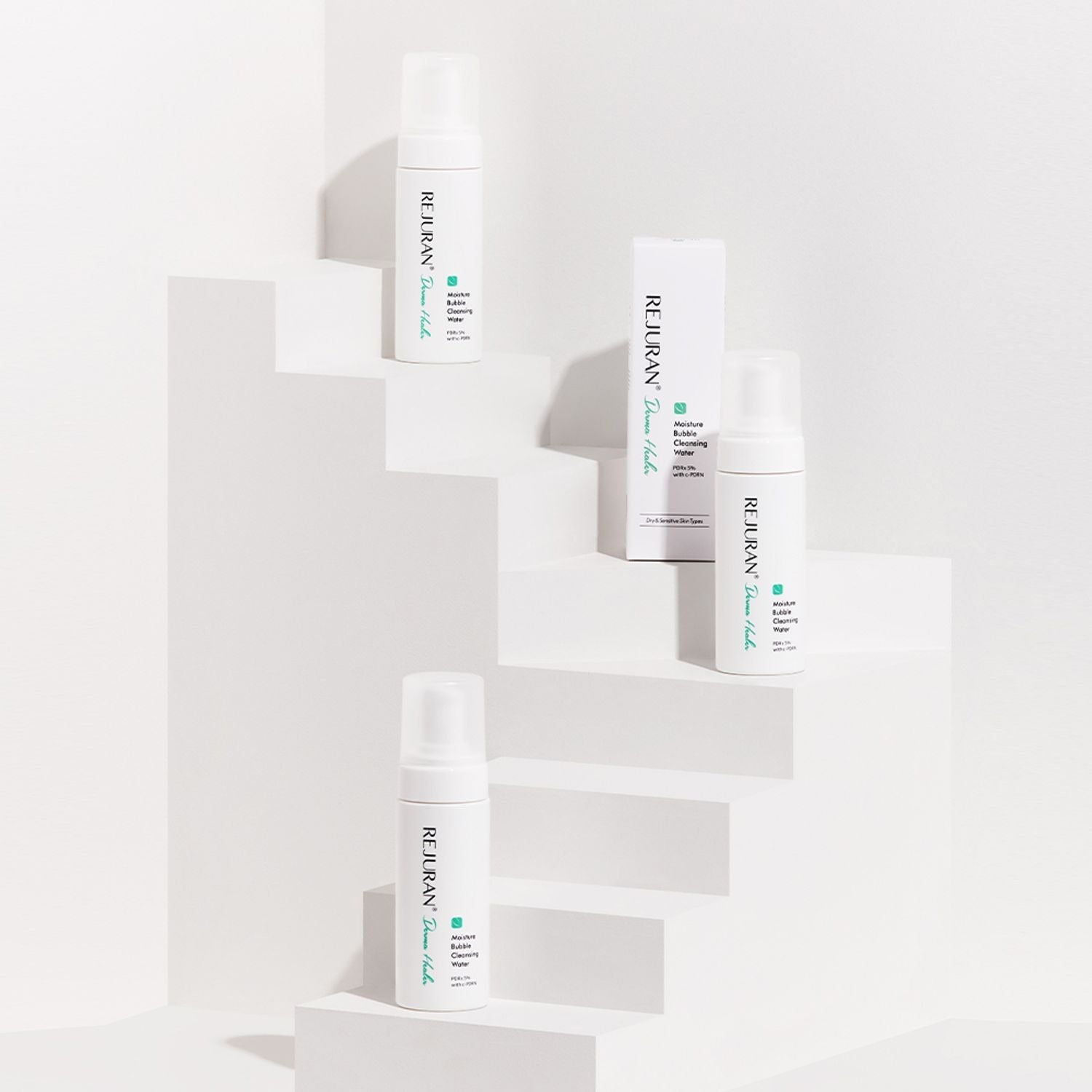 REJURAN Derma Healer Moisture Bubble Cleansing Water 150ml bottles displayed on a white stepped platform