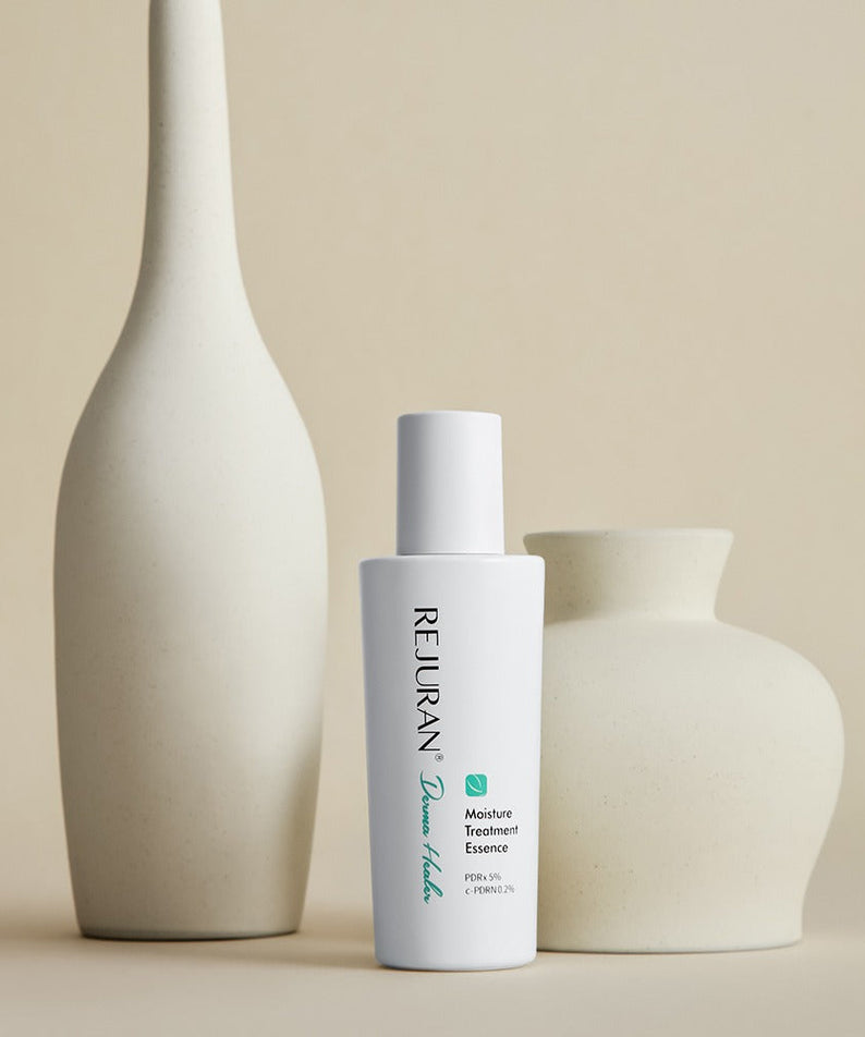 REJURAN Derma Healer Moisture Treatment Essence 70g bottle with decorative vases in a minimalist setting