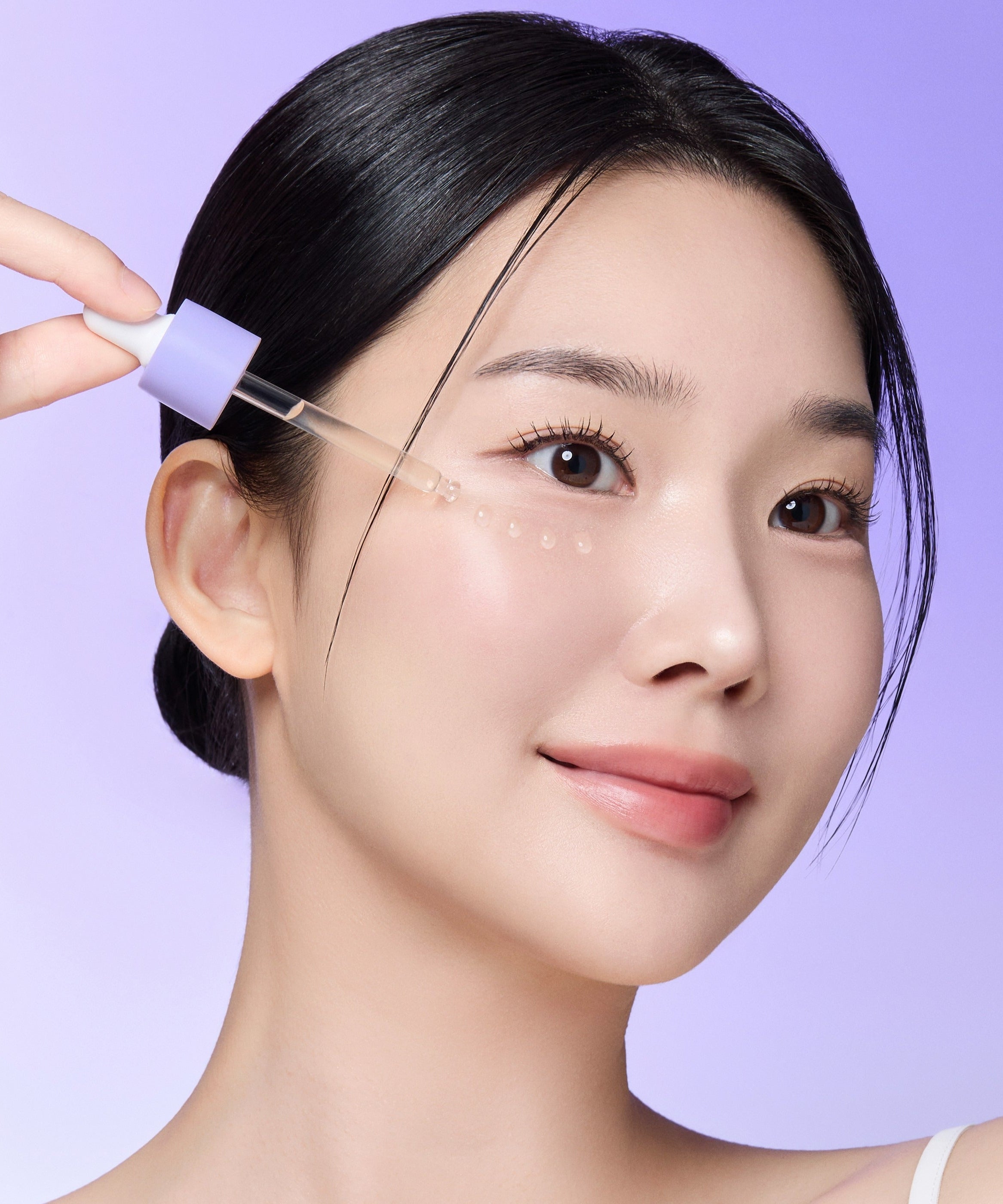 Woman applying REJURAN Derma Healer Pore Tightening Ampoule 30ml on skin with dropper