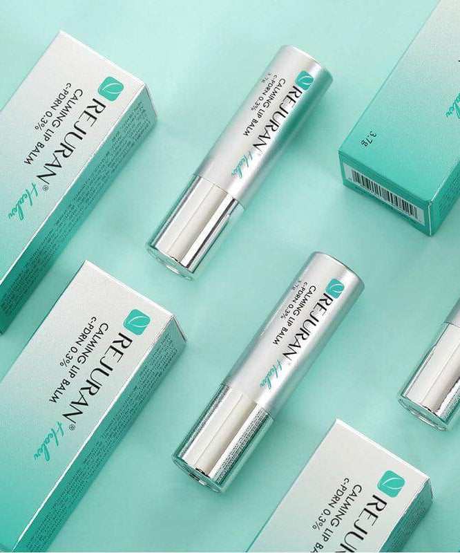 REJURAN Healer Calming Lip Balm 3.7g tubes and packaging on a teal background