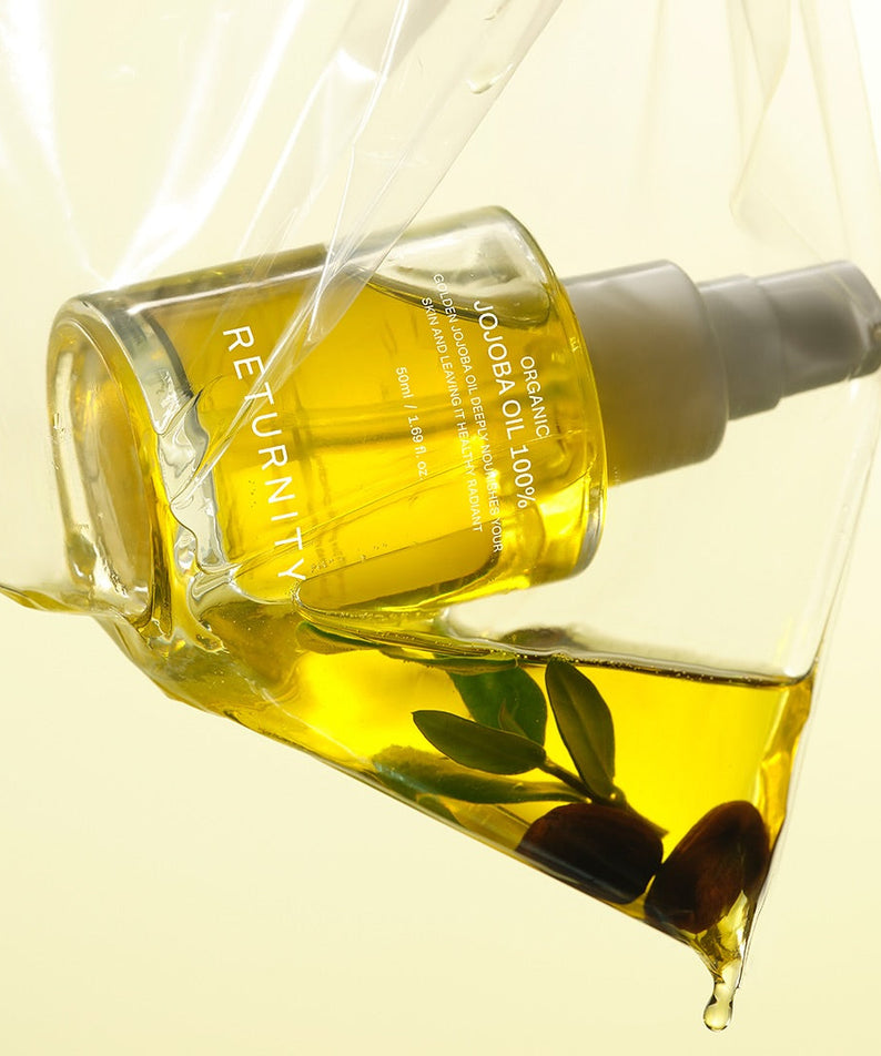 RETURNITY Organic Jojoba Oil 100% 50ml in a clear dispenser against a yellow background