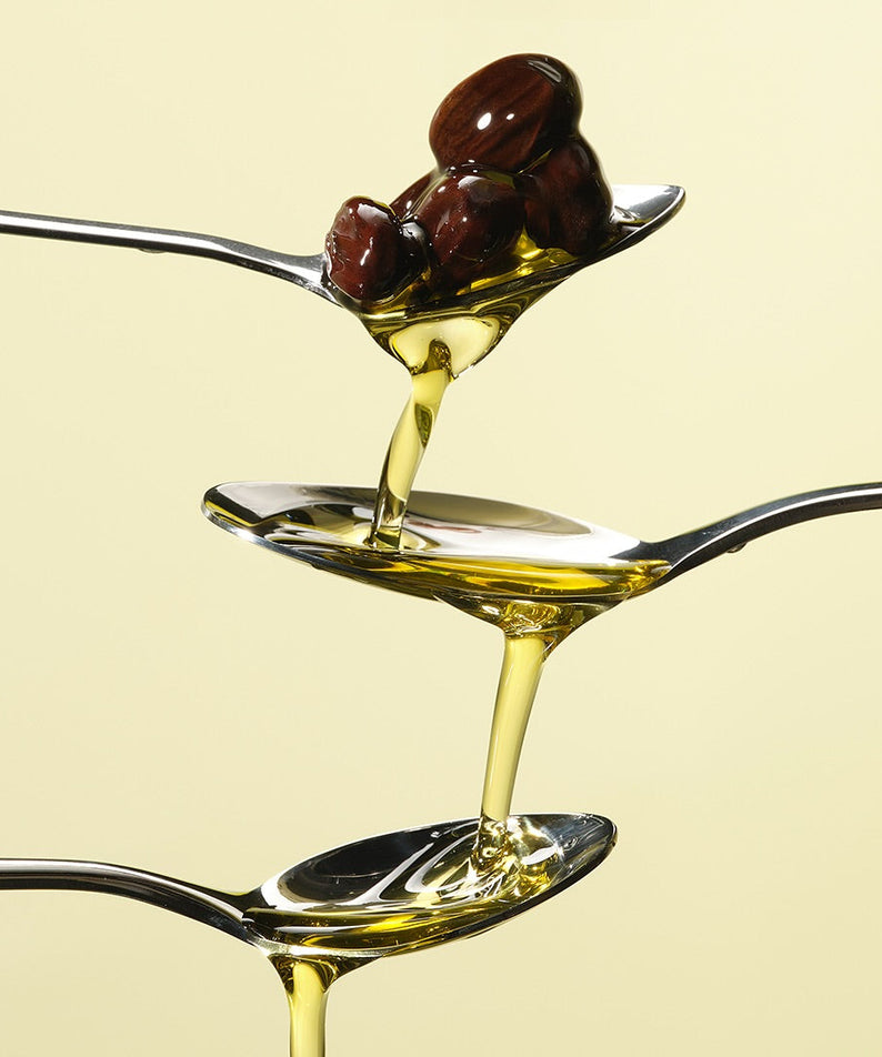 RETURNITY Organic Jojoba Oil 100% 50ml flowing from spoon, showcasing texture and quality