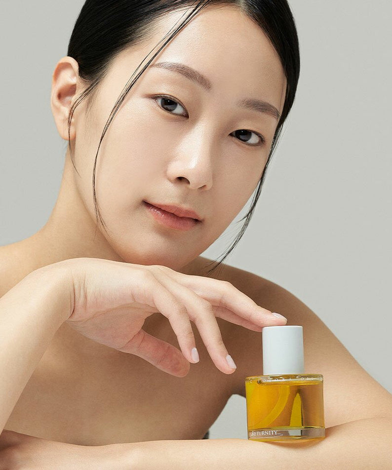 Woman holding RETURNITY Organic Jojoba Oil 100% 50ml, showcasing skincare product