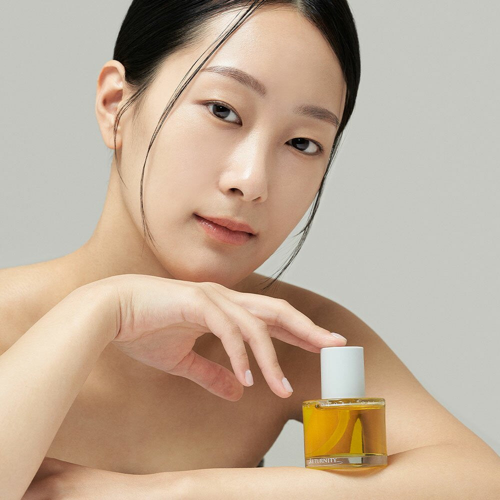 Woman holding RETURNITY Organic Jojoba Oil 100% 50ml, showcasing skincare product