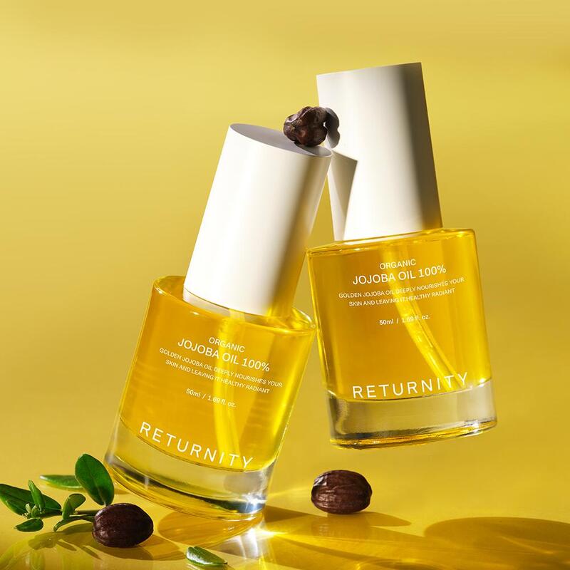 RETURNITY Organic Jojoba Oil 100% 50ml bottle on a yellow background with jojoba seeds and leaves.