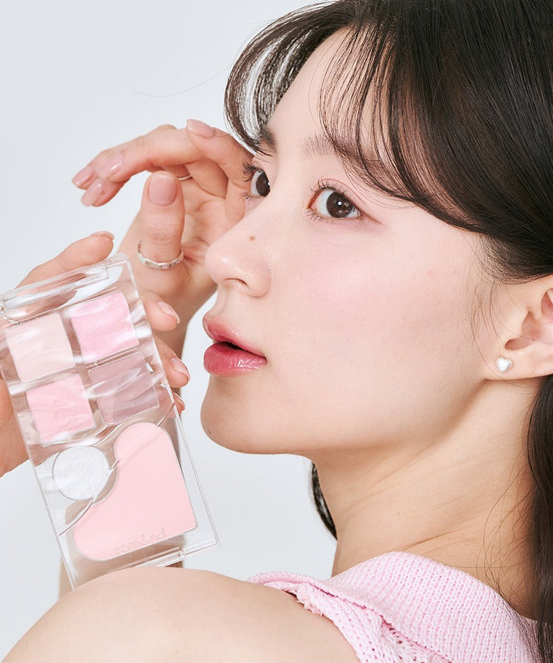 Close-up of woman holding ROMAND Bare layer palette showcasing a variety of blush tones.