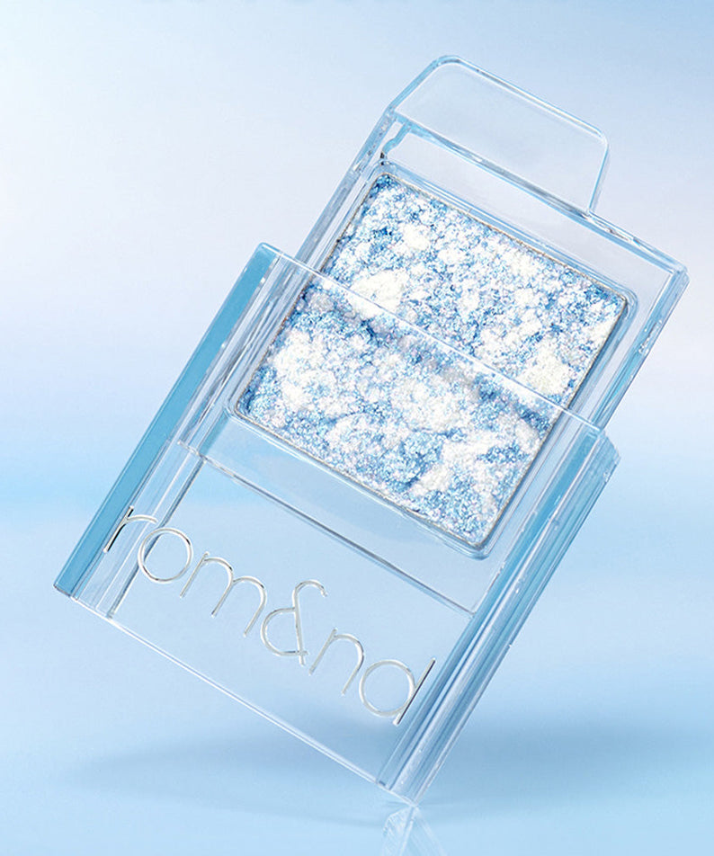 ROMAND SLIDE IN SINGLE #GURUMB glittery eyeshadow compact against blue background