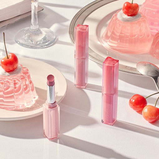 ROMAND Sheer Tinted Stick next to cherries and jelly on a table.