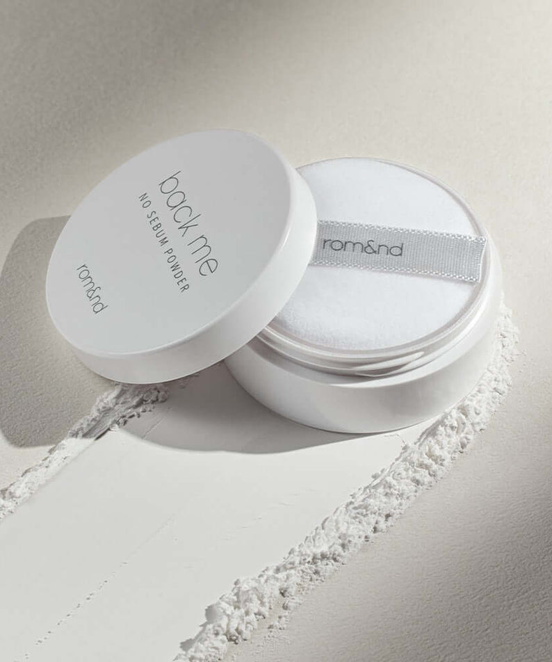 ROMAND White Rice No Sebum Powder container and puff on textured surface