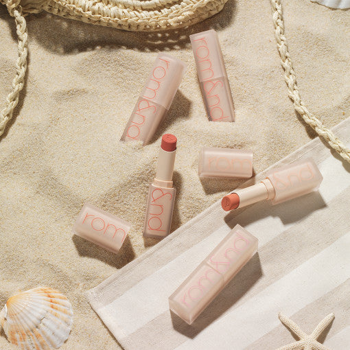 ROMAND Zero Matte Liptstick (#01 to #22) collection displayed on beach setting with seashells and rope accents highlighting summer aesthetics