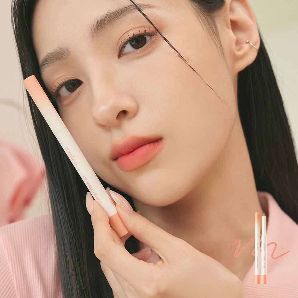 Woman holding ROMAND lip mate pencil #beovershade, showcasing soft peach lip color and smooth texture with elegant design.