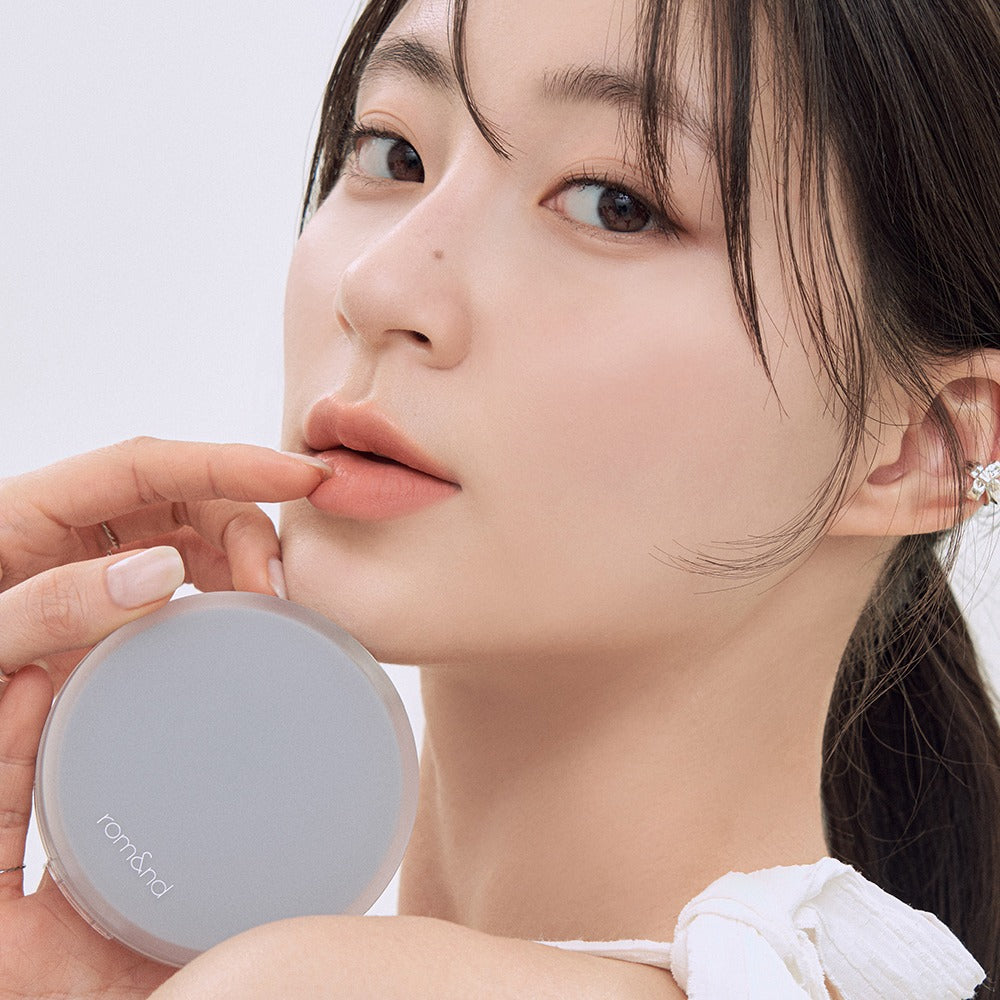 Woman holding ROMAND nu zero cushion product close-up