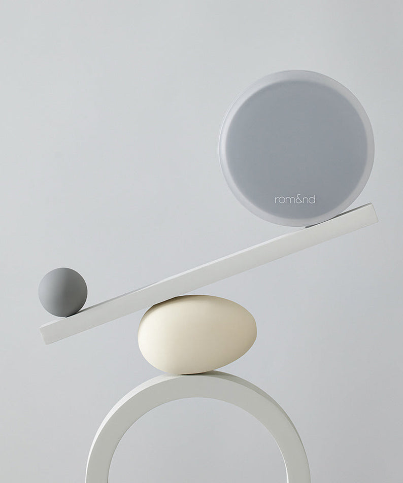 Minimalist design showcasing ROMAND nu zero cushion balancing on a geometric sculpture.