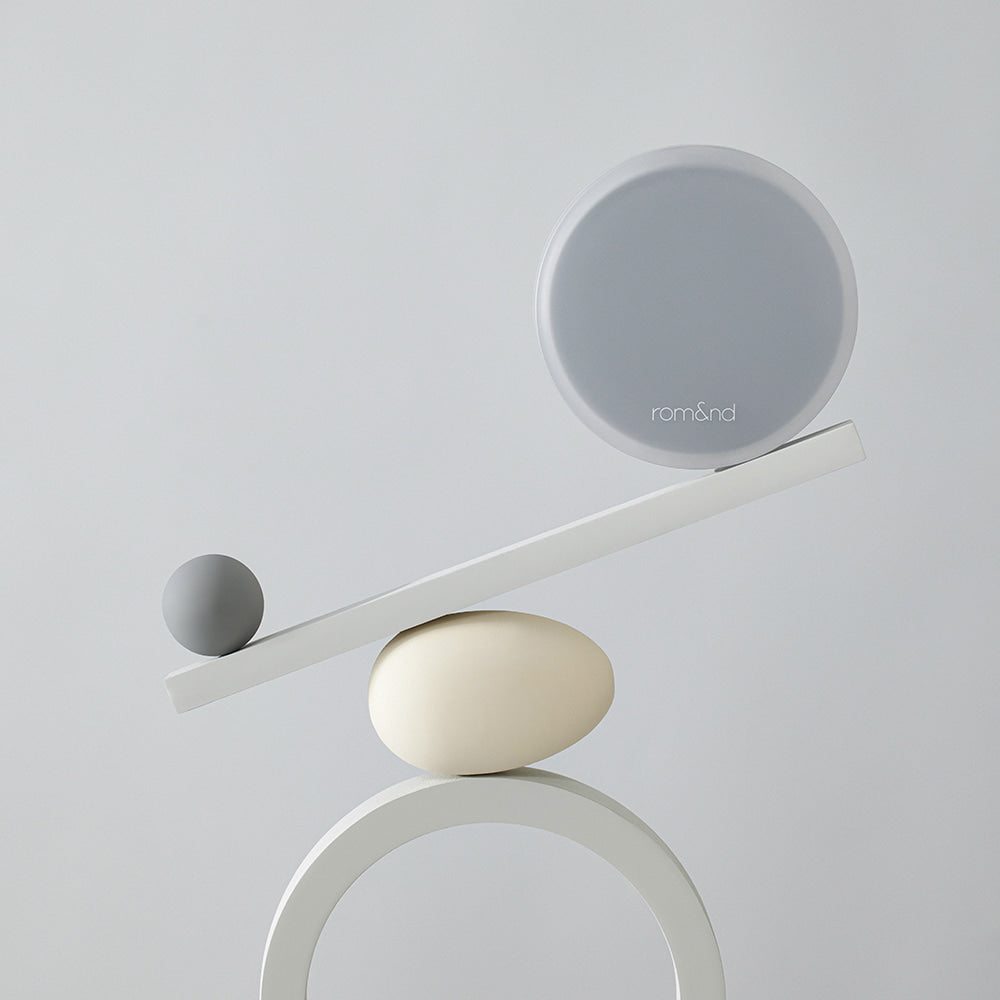 Minimalist design showcasing ROMAND nu zero cushion balancing on a geometric sculpture.