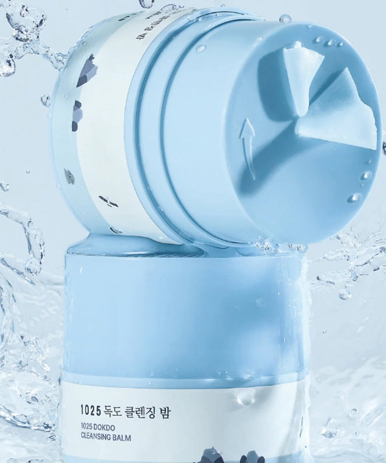 ROUND LAB 1025 Dokdo Cleansing Balm 50ml product image with blue packaging in a watery background.