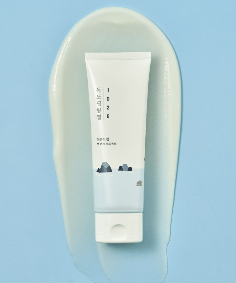 Image of ROUND LAB 1025 Dokdo Peeling Gel 120ml tube on a blue background with gel smear.