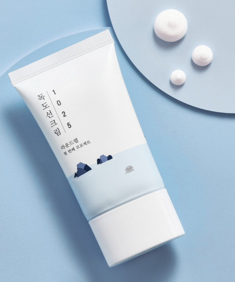 ROUND LAB 1025 Dokdo Sun Cream 50ml tube displayed on a pastel blue background