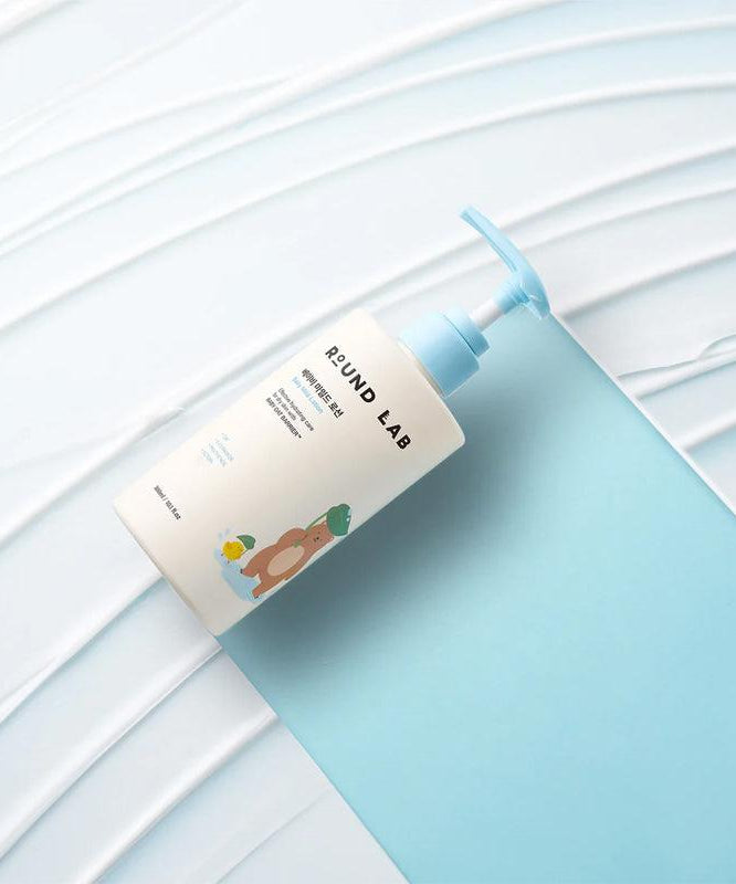 ROUND LAB Baby Mild Lotion 300ml bottle on a textured background