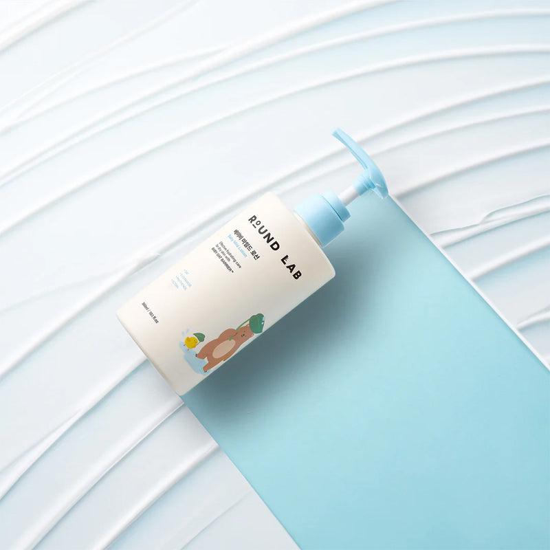 ROUND LAB Baby Mild Lotion 300ml bottle on a textured background