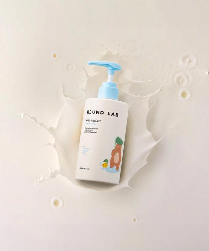 Bottle of ROUND LAB Baby Mild Lotion 300ml placed against a splash backdrop, highlighting the product's gentle formulation.
