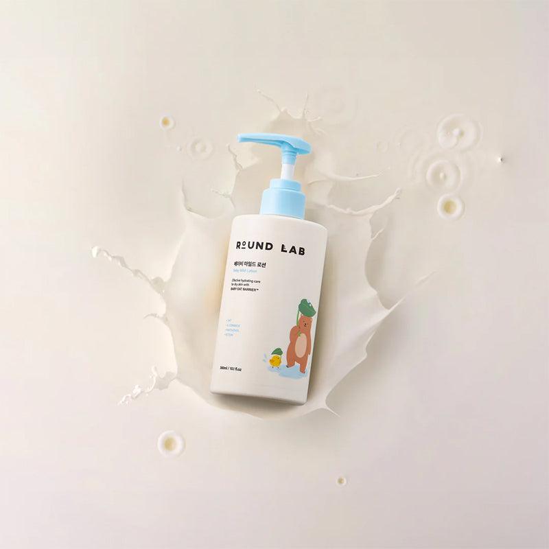 Bottle of ROUND LAB Baby Mild Lotion 300ml placed against a splash backdrop, highlighting the product's gentle formulation.