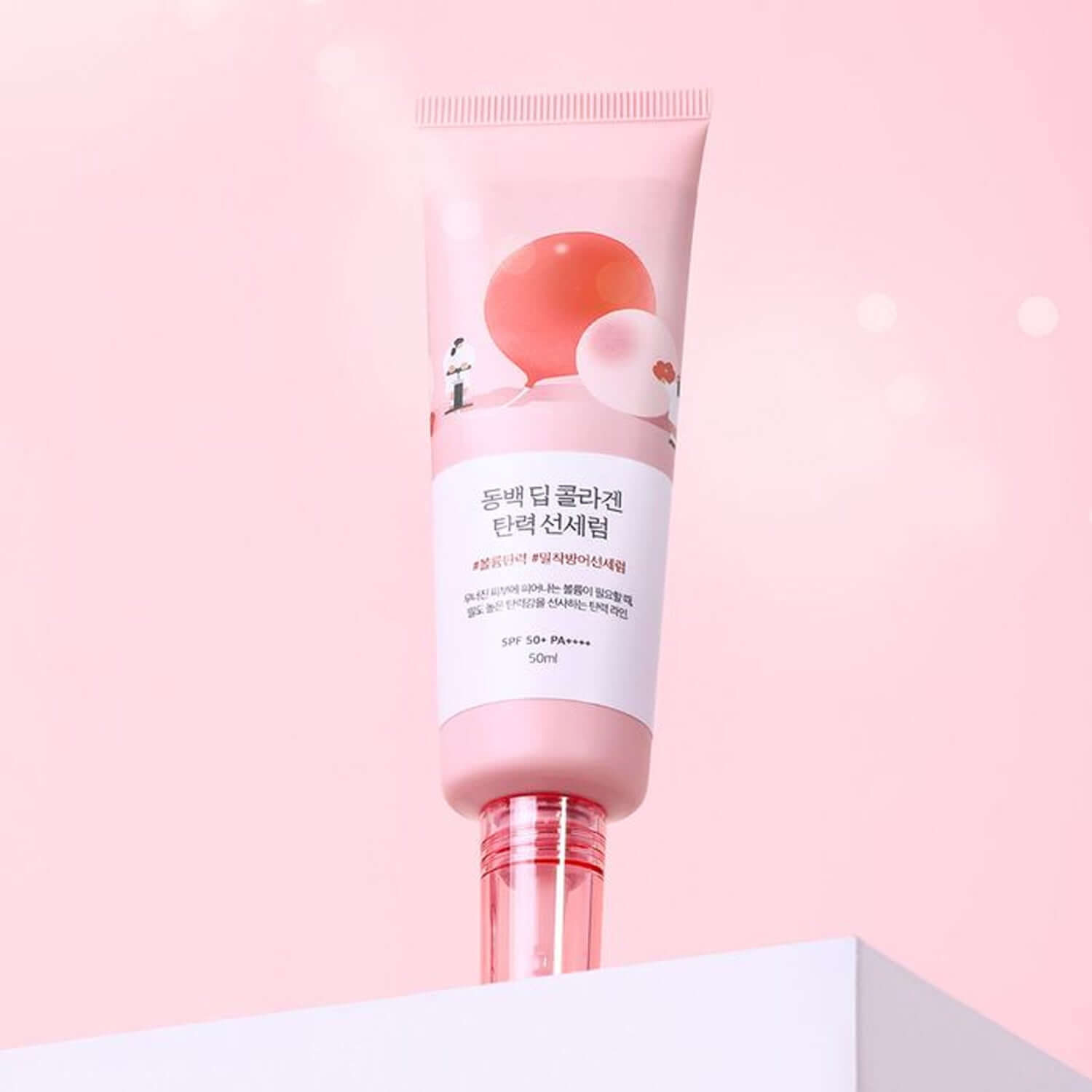 ROUND LAB Dongbaek Deep Collagen Elasticity Sun Serum 50ml, pink design bottle on a soft pink background.