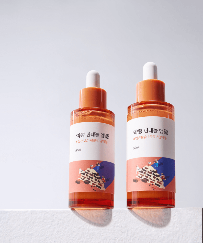 Two bottles of ROUND LAB Pine Calming Cica Ampoule 30ml displayed on a white surface, showcasing skincare packaging.