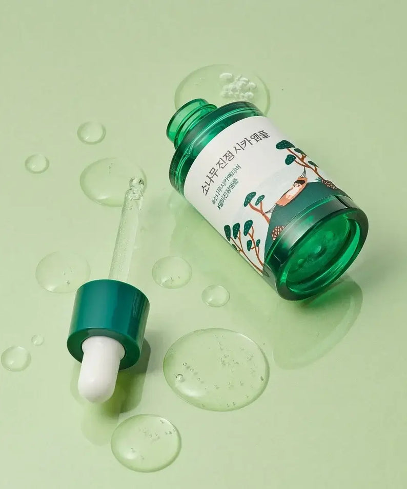 ROUND LAB Pine Calming Cica Ampoule 30ml bottle with dropper on a green background
