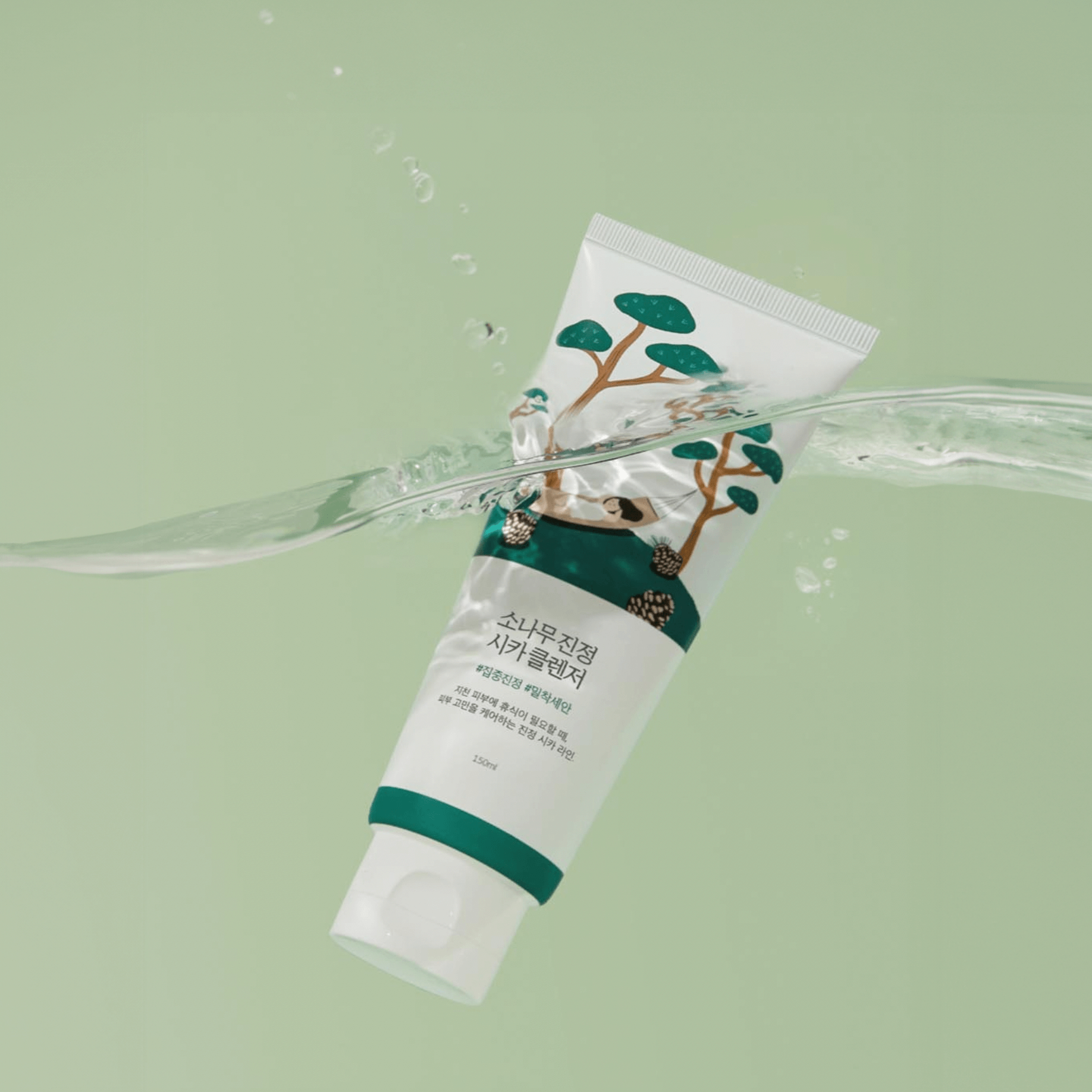 Bottle of ROUND LAB Pine Calming Cica Cleanser 150ml with water backdrop, highlighting soothing skincare properties.