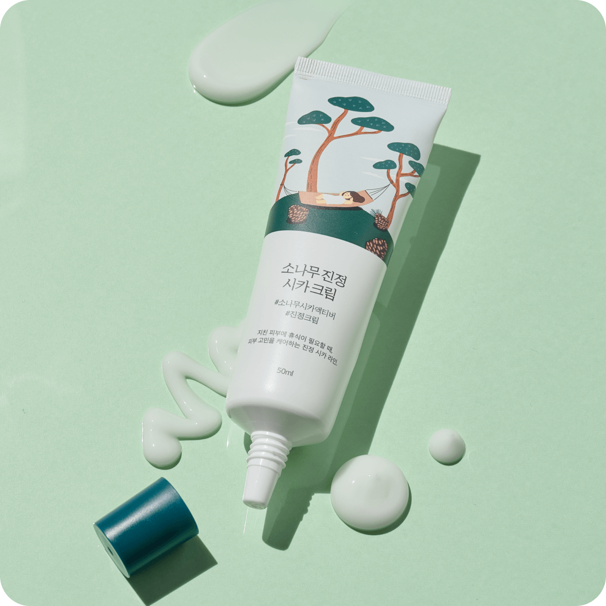 ROUND LAB Pine Calming Cica Cream 50ml tube on green background with cream texture visible