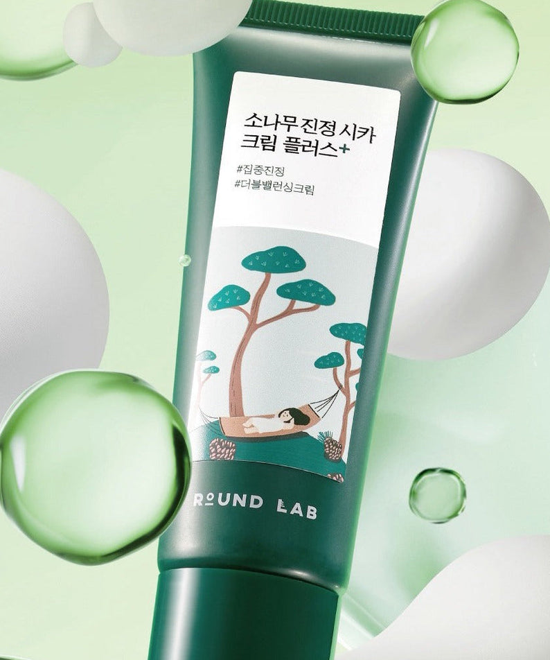 ROUND LAB Pine Calming Cica Cream Plus 60ml tube with green design and floating bubbles, skincare product for soothing and calming skin.