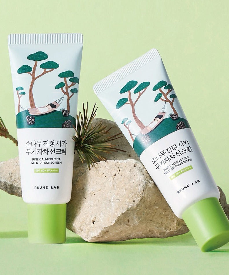 ROUND LAB Pine Tree Calming Cica Mineral Sunscreen 40ml tubes on rock and green background