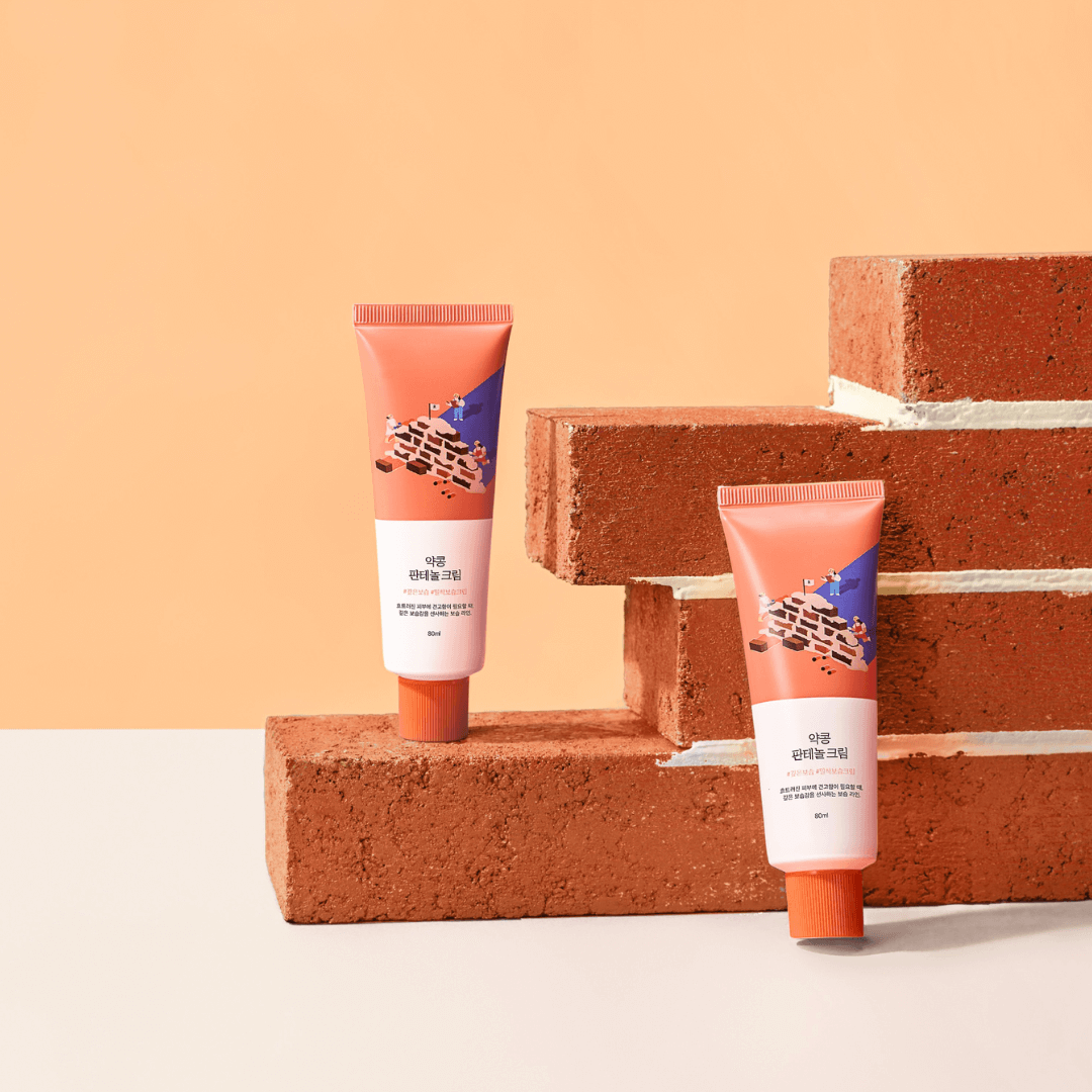 ROUND LAB Yakkong Panthenol Cream 80ml displayed with decorative brick background.