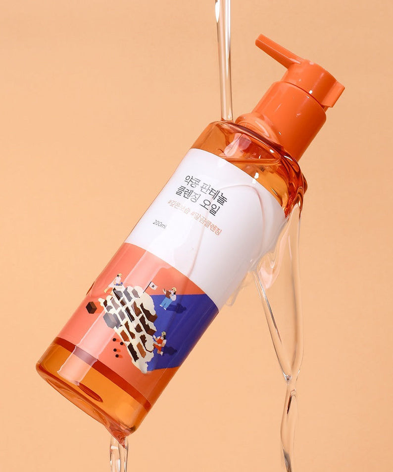 ROUNDLAB Yakkong Panthenol Cleansing oil 200ml bottle with orange and white design on a peach background.