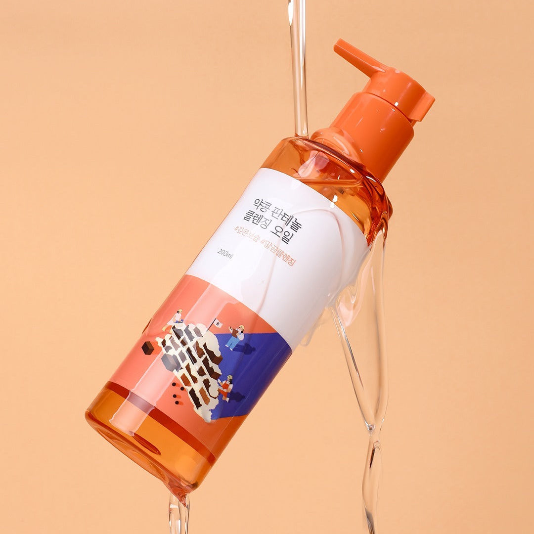 ROUNDLAB Yakkong Panthenol Cleansing oil 200ml bottle with orange and white design on a peach background.