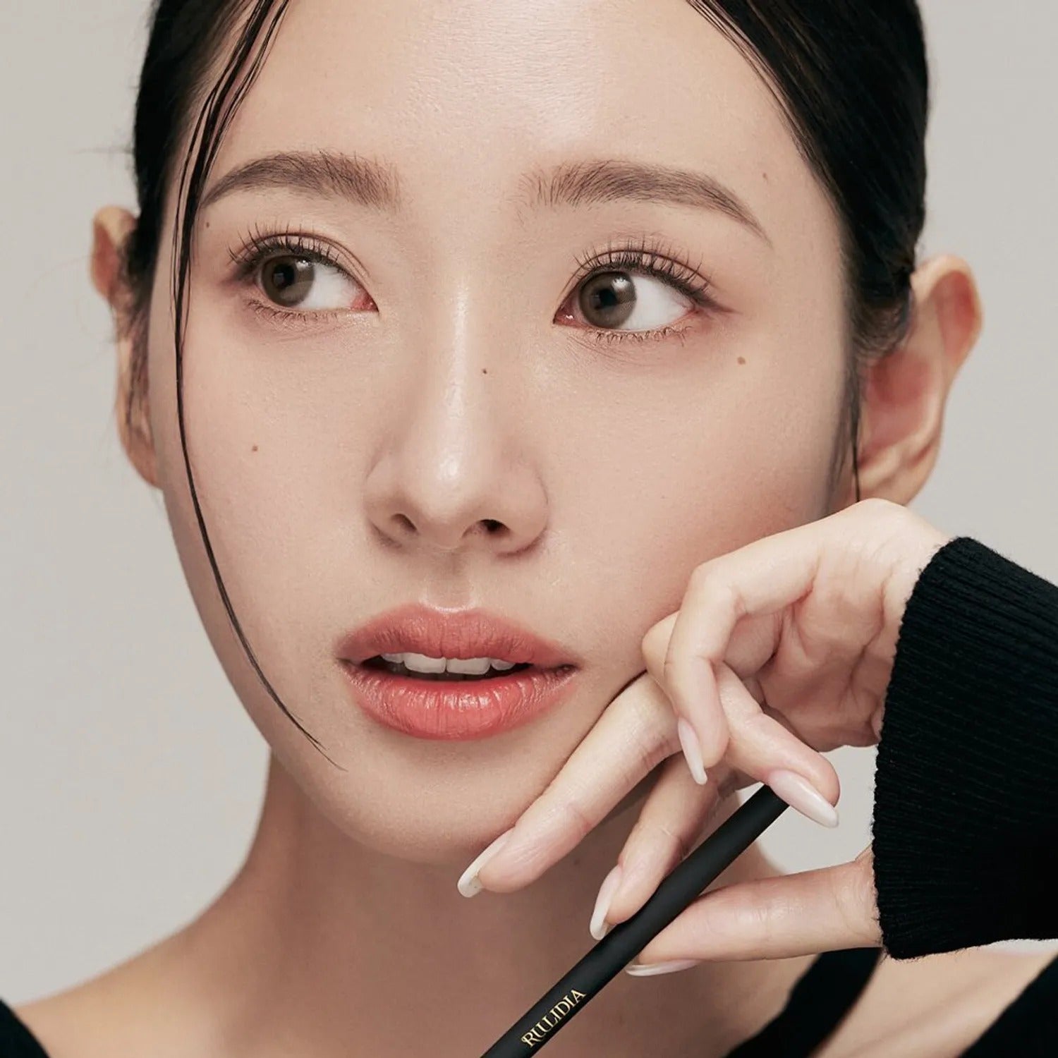 Woman using RULIDIA Easy Detail Brow for precise eyebrow detailing and makeup application.