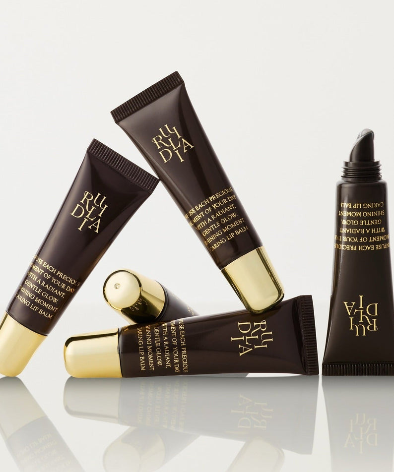 RULIDIA Shining Moment Caring Lip Balm 8g tubes arranged artistically on a white background.