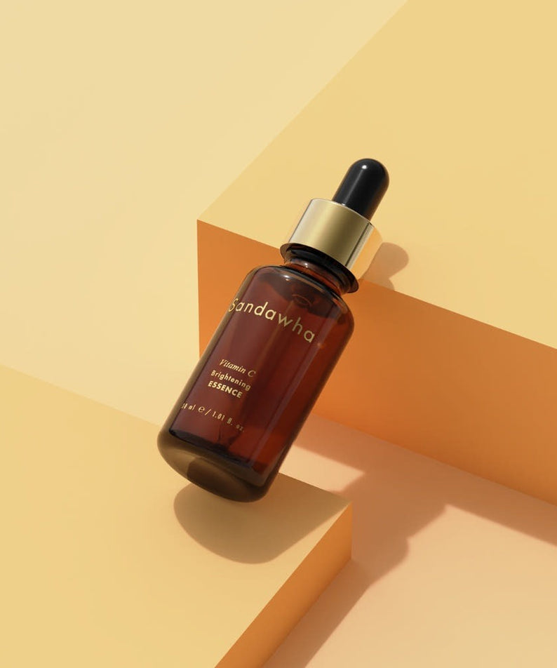 SANDAWHA Vitamin C Whitening Essence 30ml bottle on a geometric yellow background