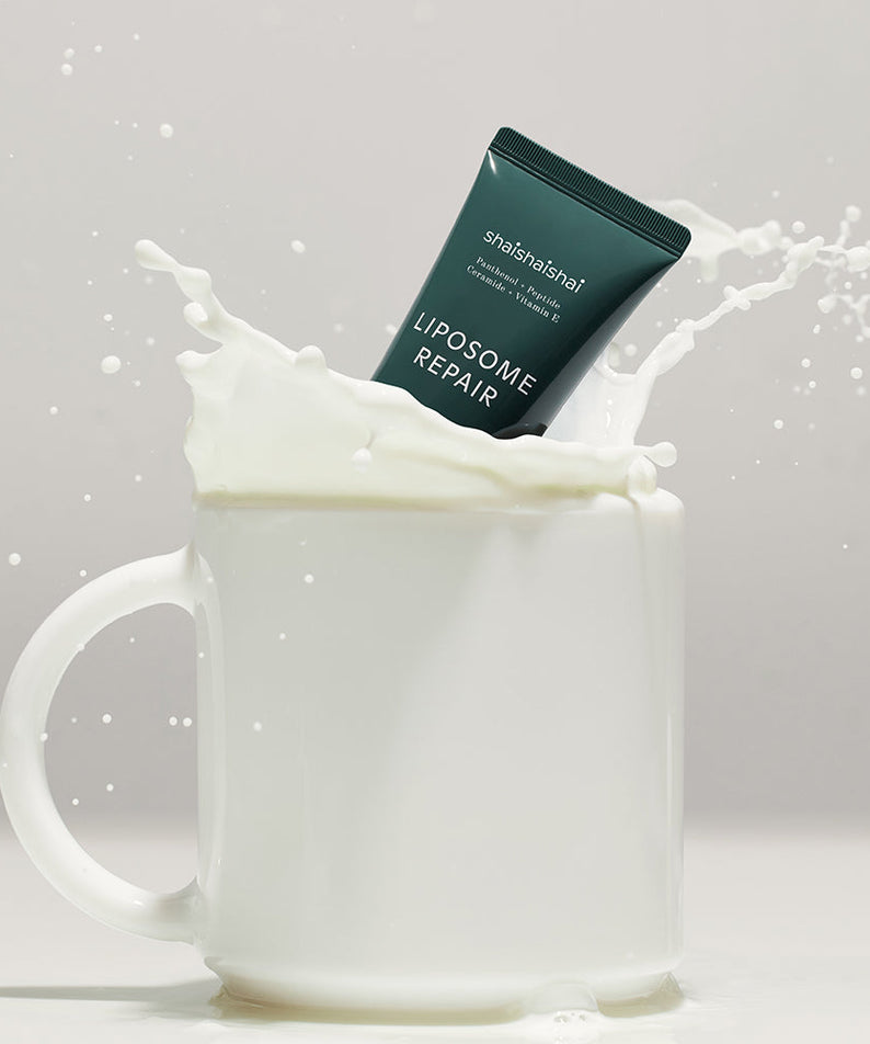 SHAISHAISHAI Liposome Repair Milky Cream 50ml sitting in a splash of milk inside a white mug.