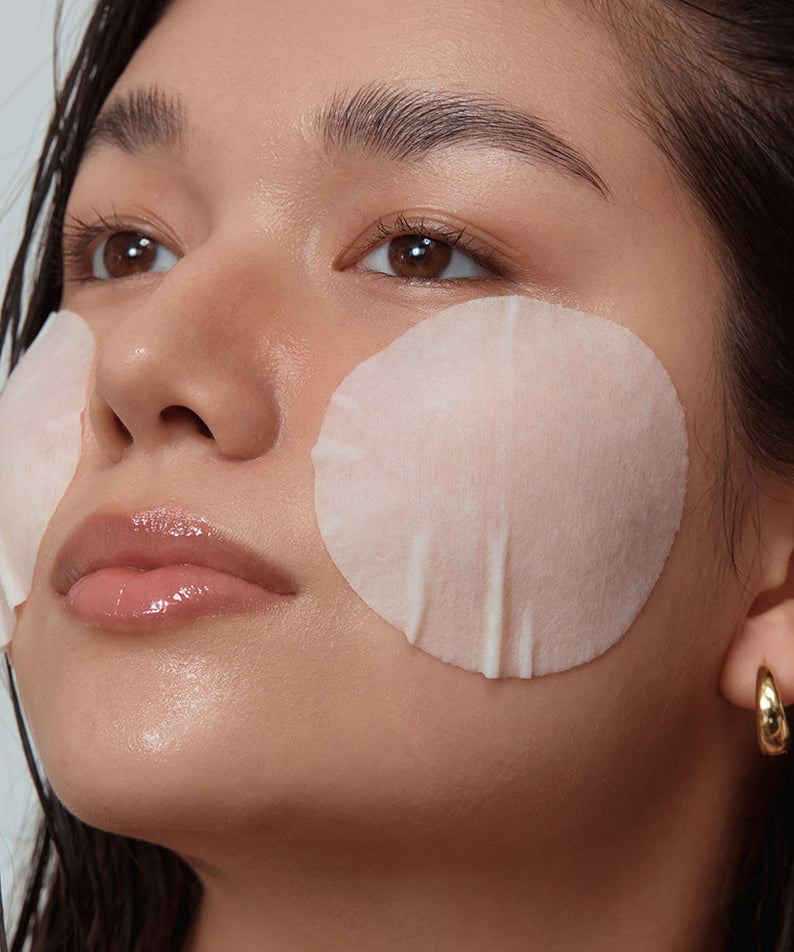Woman using SHAISHAISHAI Repair Milky Skin Peel Pad 60 Pads 120ml on cheeks for skincare treatment.