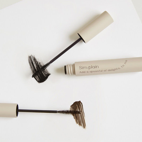 Open and closed tubes of SIM:PLAIN Slim Mascara with swatches on white background, showcasing black and brown shades for perfect lashes.